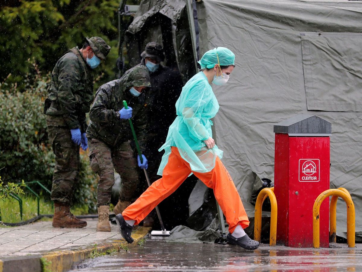 Foto: Personal sanitario y militares trabajan en el hospital de campaña frente al Gregorio Marañón, en Madrid. (EFE)