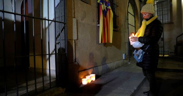 Foto: Una mujer enciende una vela en el Convento dels Caputxins de Sarrià donde consellers y diputados soberanistas iniciaron su huelga de hambre. (EFE)