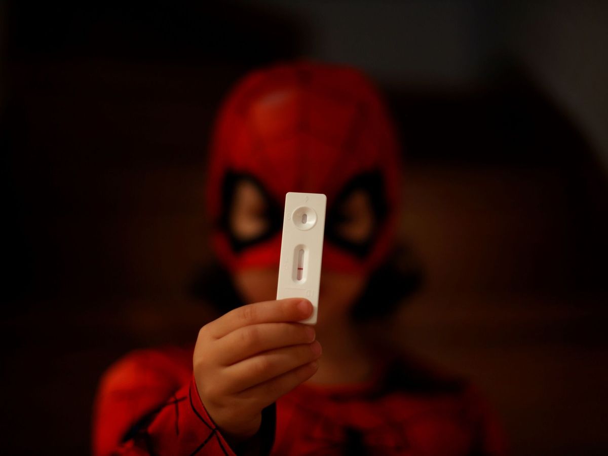 Foto: Un niño disfrazado de Spiderman muestra un test de antígenos de resultado negativo. (EFE/Cabalar)
