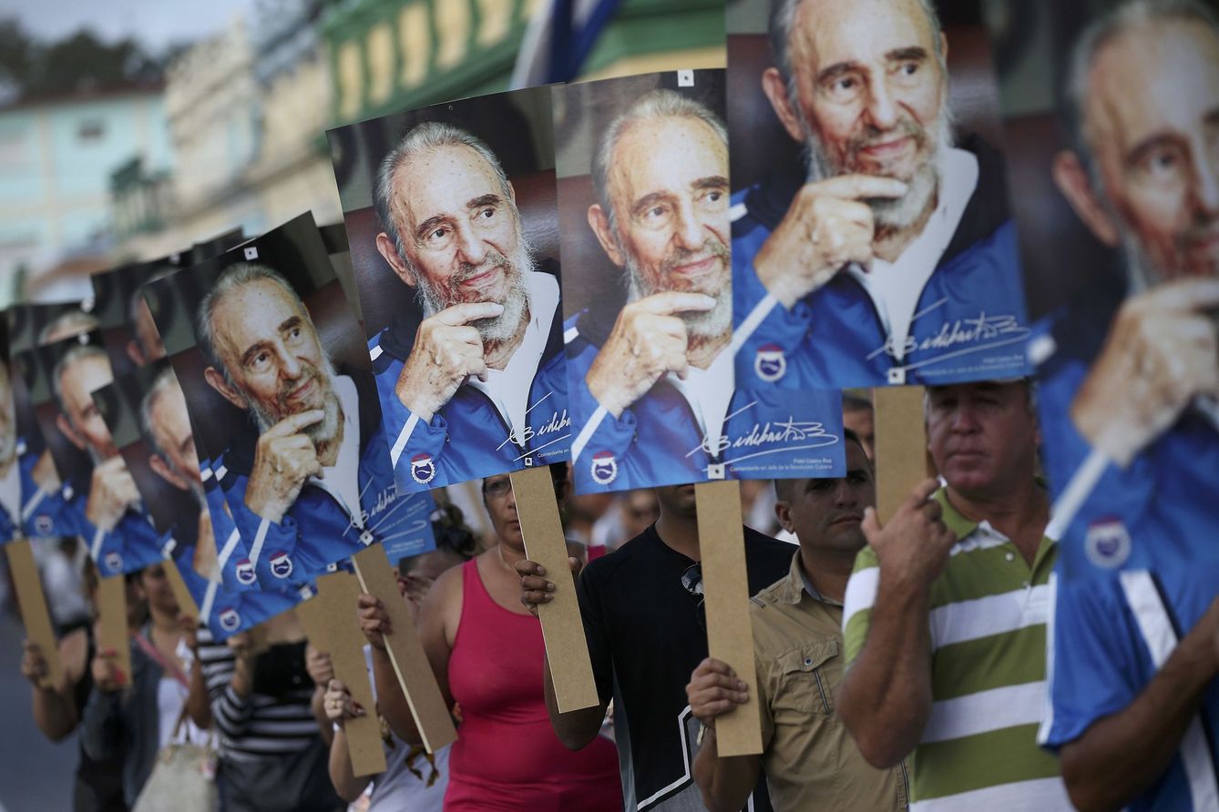 Un grupo de personas enarbola carteles con la cara de Fidel Castro mientras espera la caravana funeraria del líder cubano, en Las Tunas, el 2 de diciembre de 2016. (Reuters)