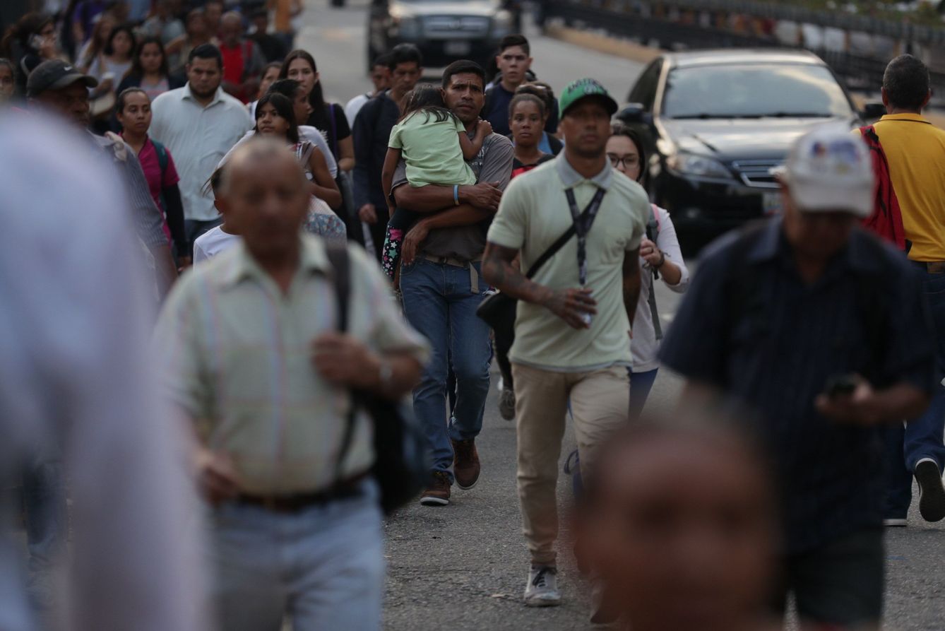 Venezolanos se trasladan a pie durante el apagón eléctrico en Caracas, el jueves por la tarde. (EFE)