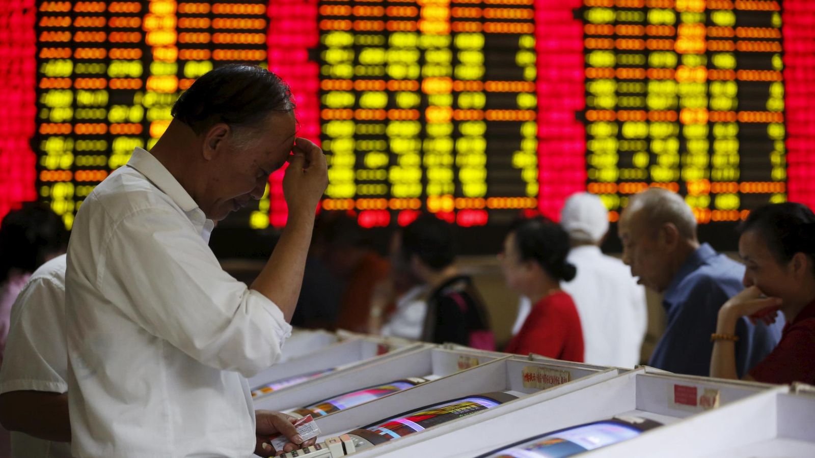 Foto: Un inversor muestra un gesto preocupado ante las pantallas de cotizaciones de la bolsa china.
