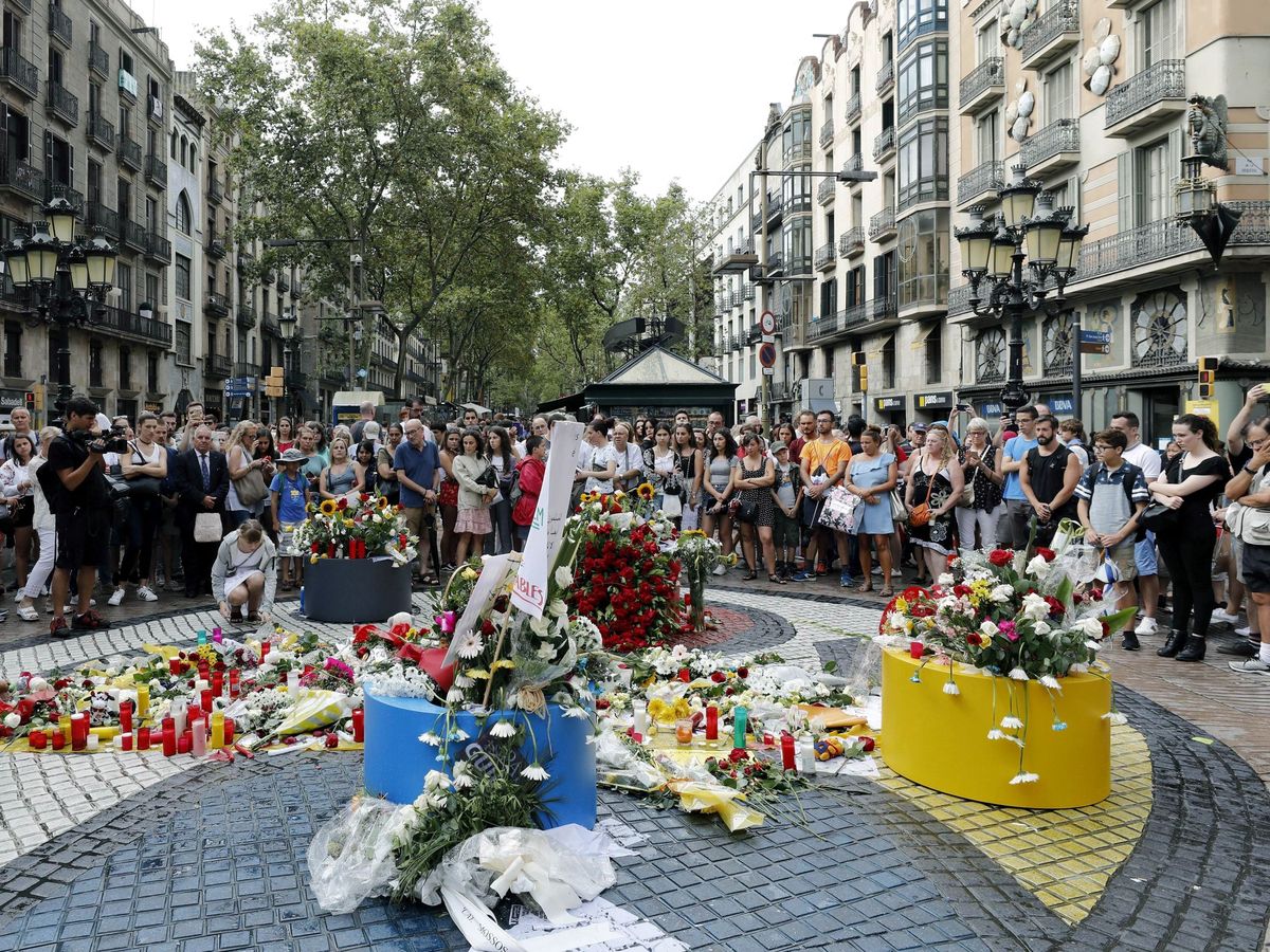 Foto: Un grupo de personas deposita flores en el mosaico de Miró en las Ramblas en recuerdo de las víctimas de los atentados del 17-A en Barcelona y Cambrils. (EFE)