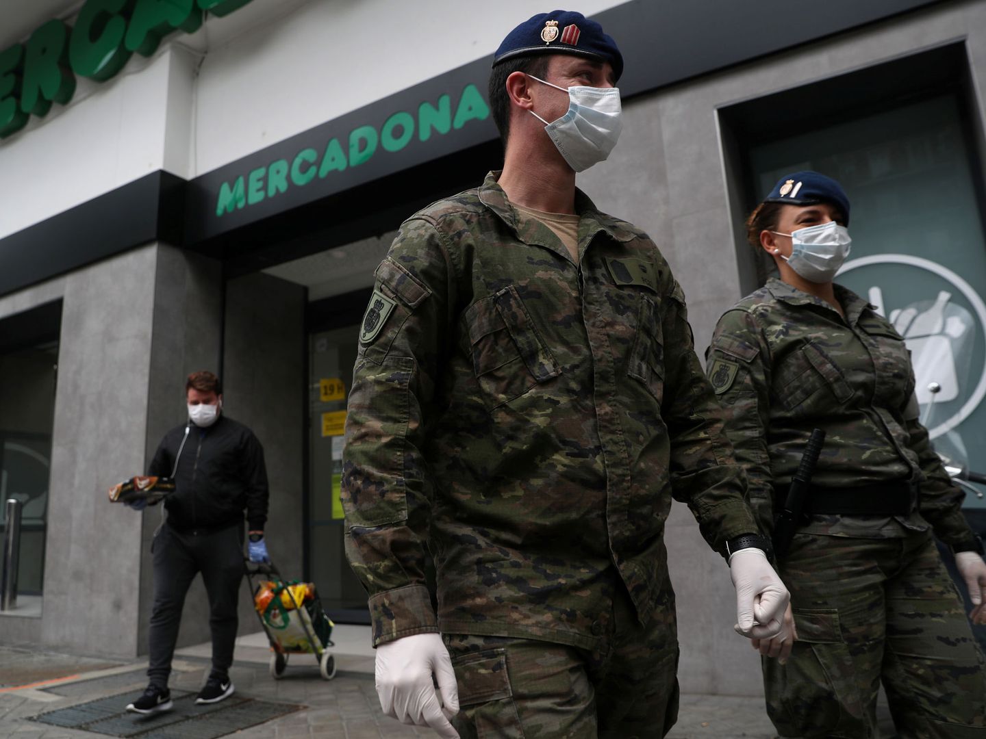 Miembros de la Guardia Real pasan frente a un Mercadona. (Reuters)