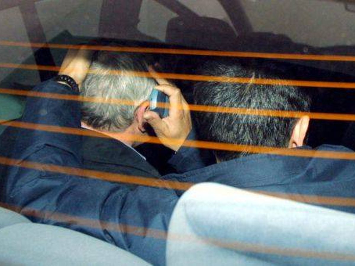 Foto: Nené Barral, a la izquierda, dentro del coche policial cuando fue detenido en 2001. (EFE)