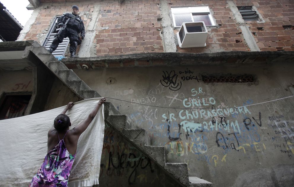 Una mujer tiende ropa ante un agente durante una operación en la Maré, en Río (Reuters).