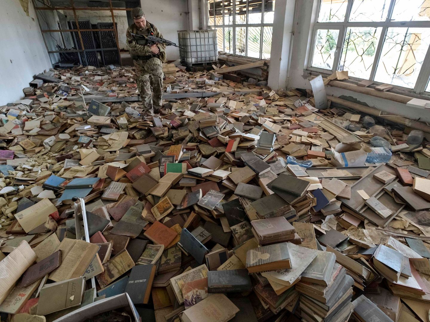 Un soldado ucraniano observa los destrozos en una biblioteca en la ciudad de Maryinka.