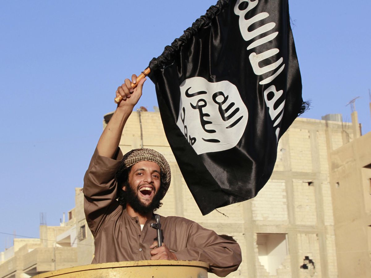Foto: Un combatiente con la bandera del ISIS en Raqqa. (Reuters)