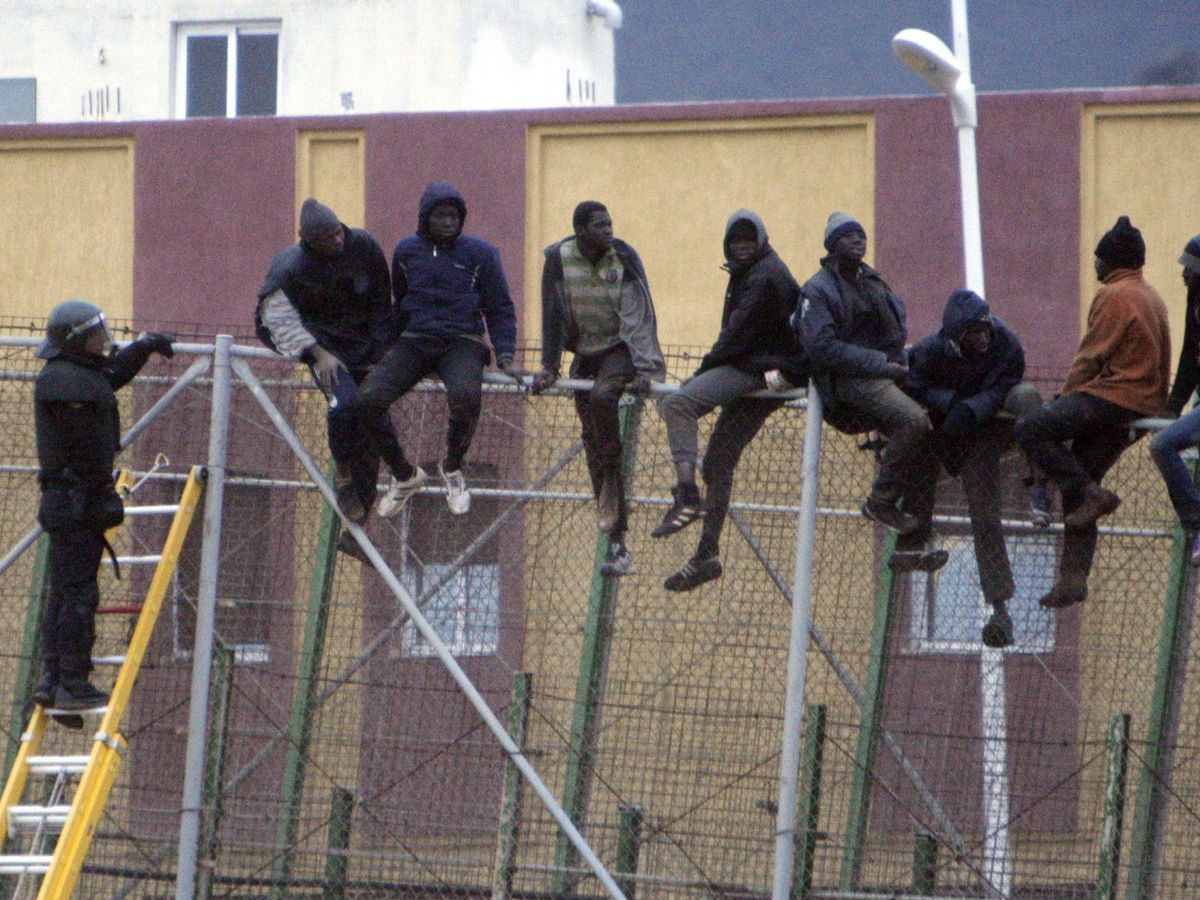 Foto: Una veintena de inmigrantes subidos a la valla de Melilla, en una imagen de 2015. (EFE)