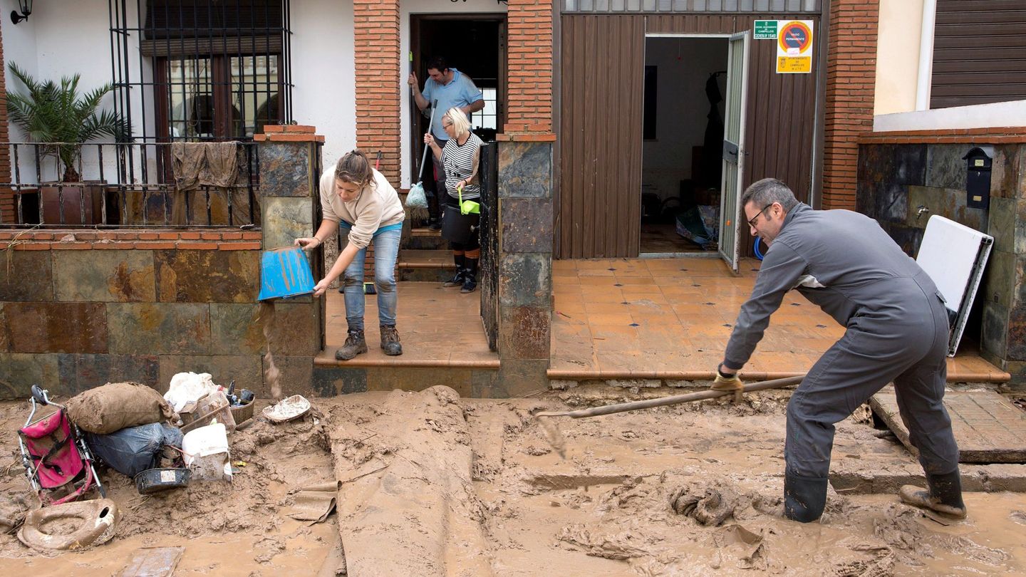 Vecinos de la localidad malagueña de Campillos limpian los desperfectos en viviendas. (EFE)