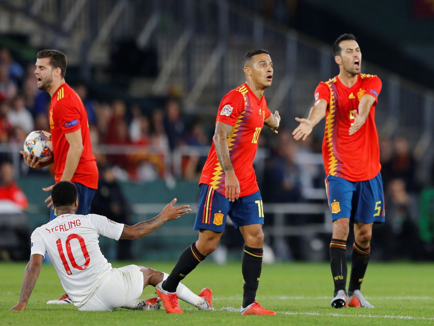Sergio Busquets, junto a Thiago, se queja al árbitro con Sterling en el suelo. (Reuters)
