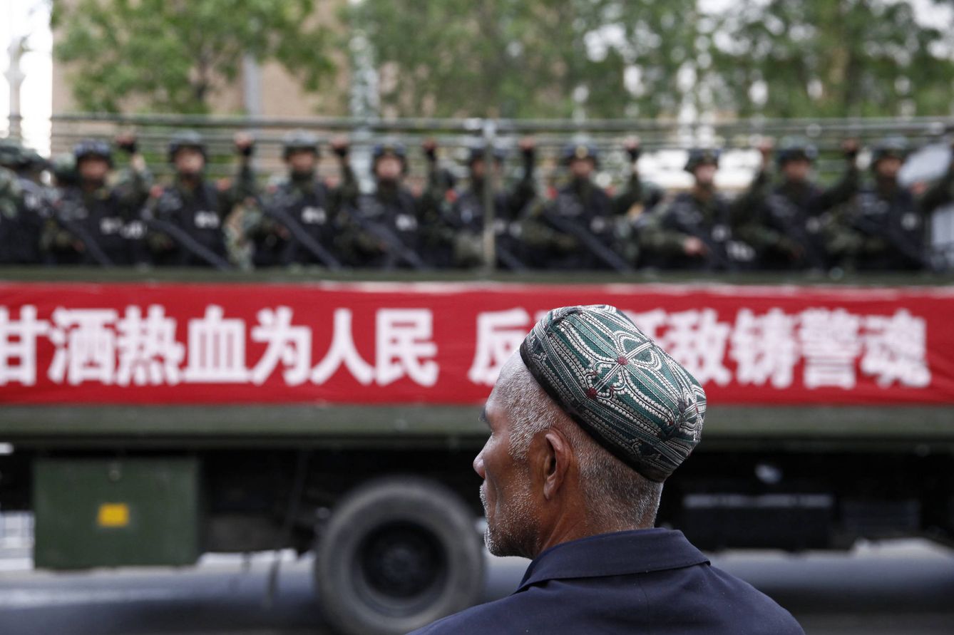 Un hombre uigur observa el despliegue de policías paramilitares durante un ejercicio antiterrorista en Urumqi, Xinjiang, en mayo de 2014. (Reuters)