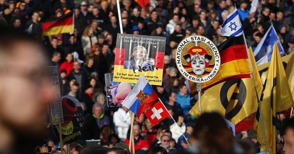 Foto: Seguidores de PEGIDA sostienen carteles contra Angela Merkel durante una manifestación en Dresde. (Reuters) 