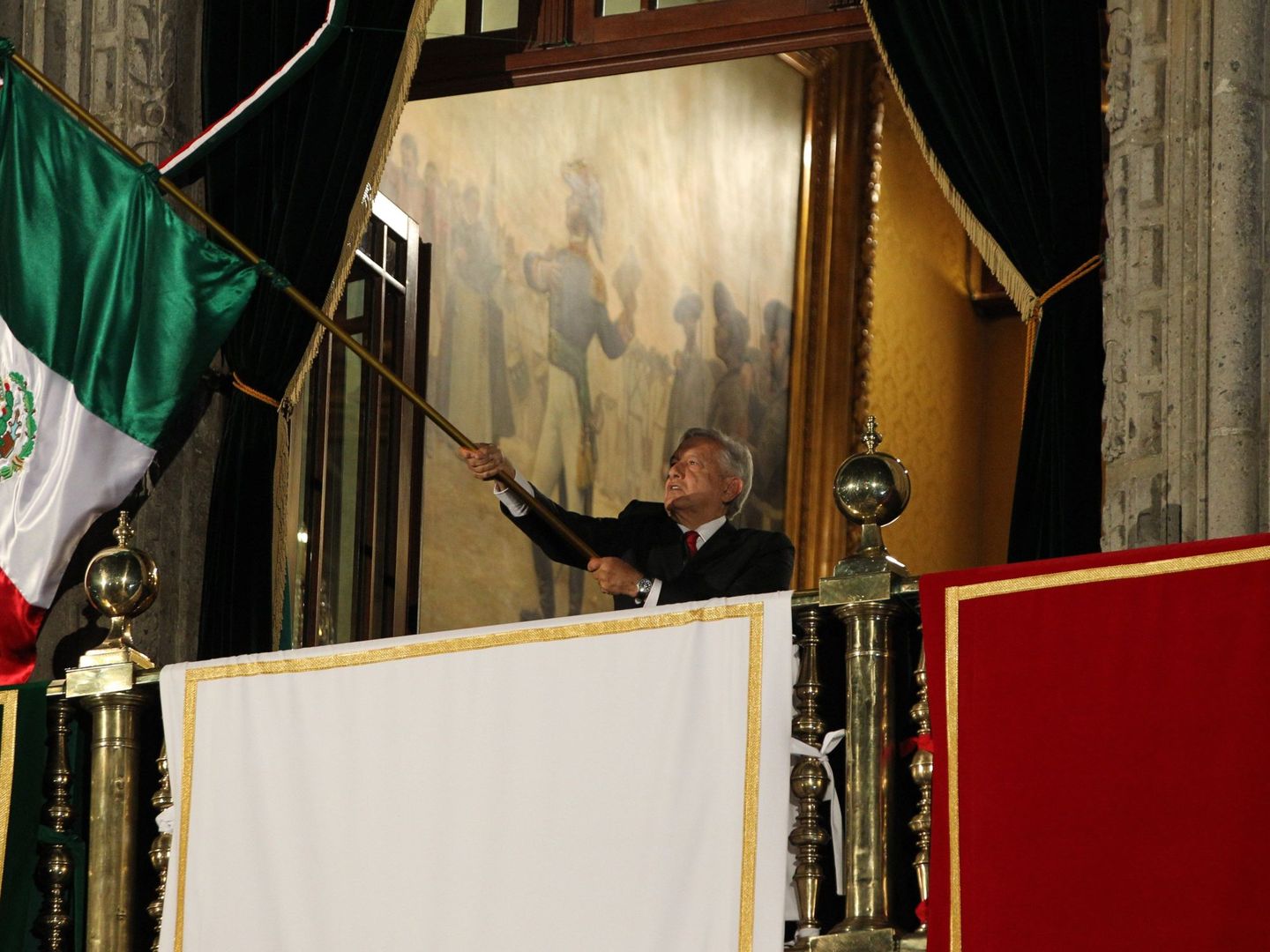 El presidente de México ondea la bandera nacional durante la conmemoración del aniversario número 209 del Grito de Independencia. (EFE)
