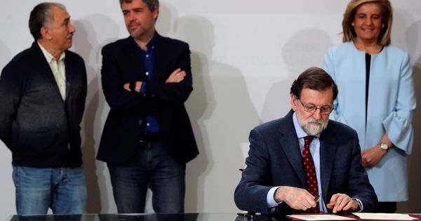 Foto: Mariano Rajoy, con Fátima Báñez al fondo, firmando el acuerdo del SMI. (EFE)