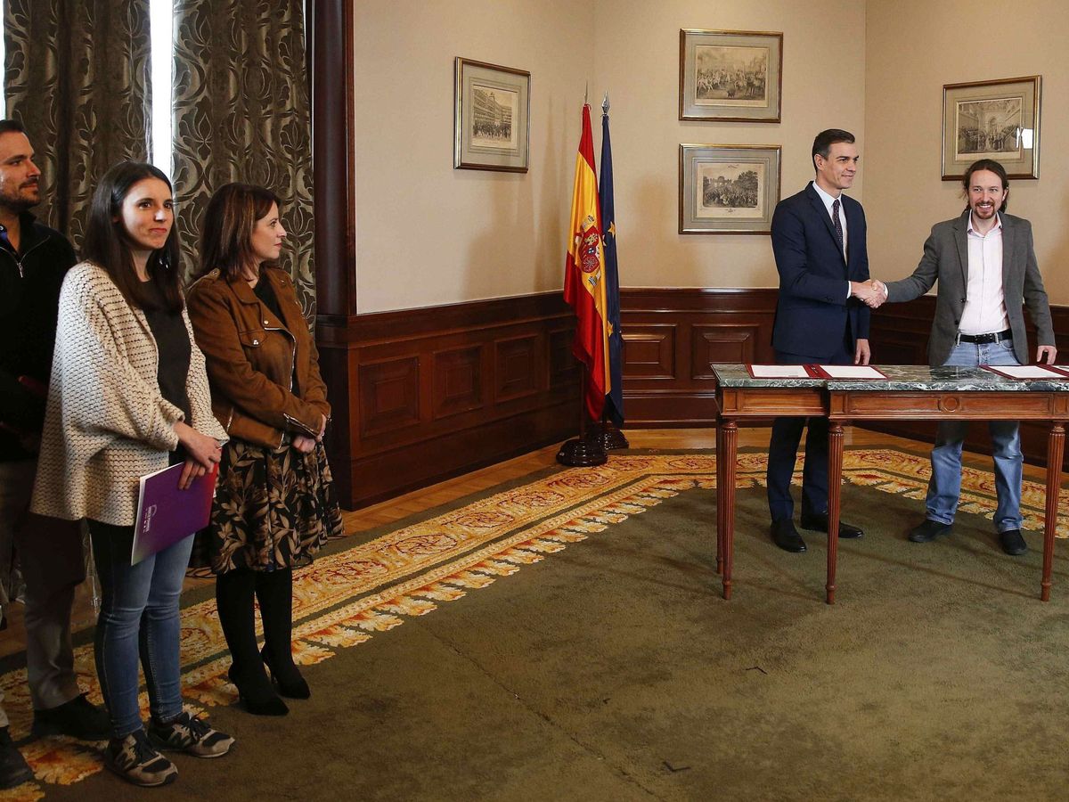 Foto: Pedro Sánchez y Pablo Iglesias firman el acuerdo ante la mirada de Adriana Lastra, Irene Montero y Alberto Garzón, este 12 de noviembre. (EFE)