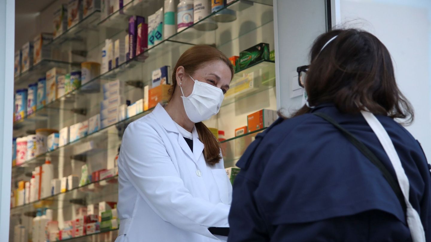 Una clienta conversa con una empleada a las puertas de una farmacia del centro de Madrid (EFE)