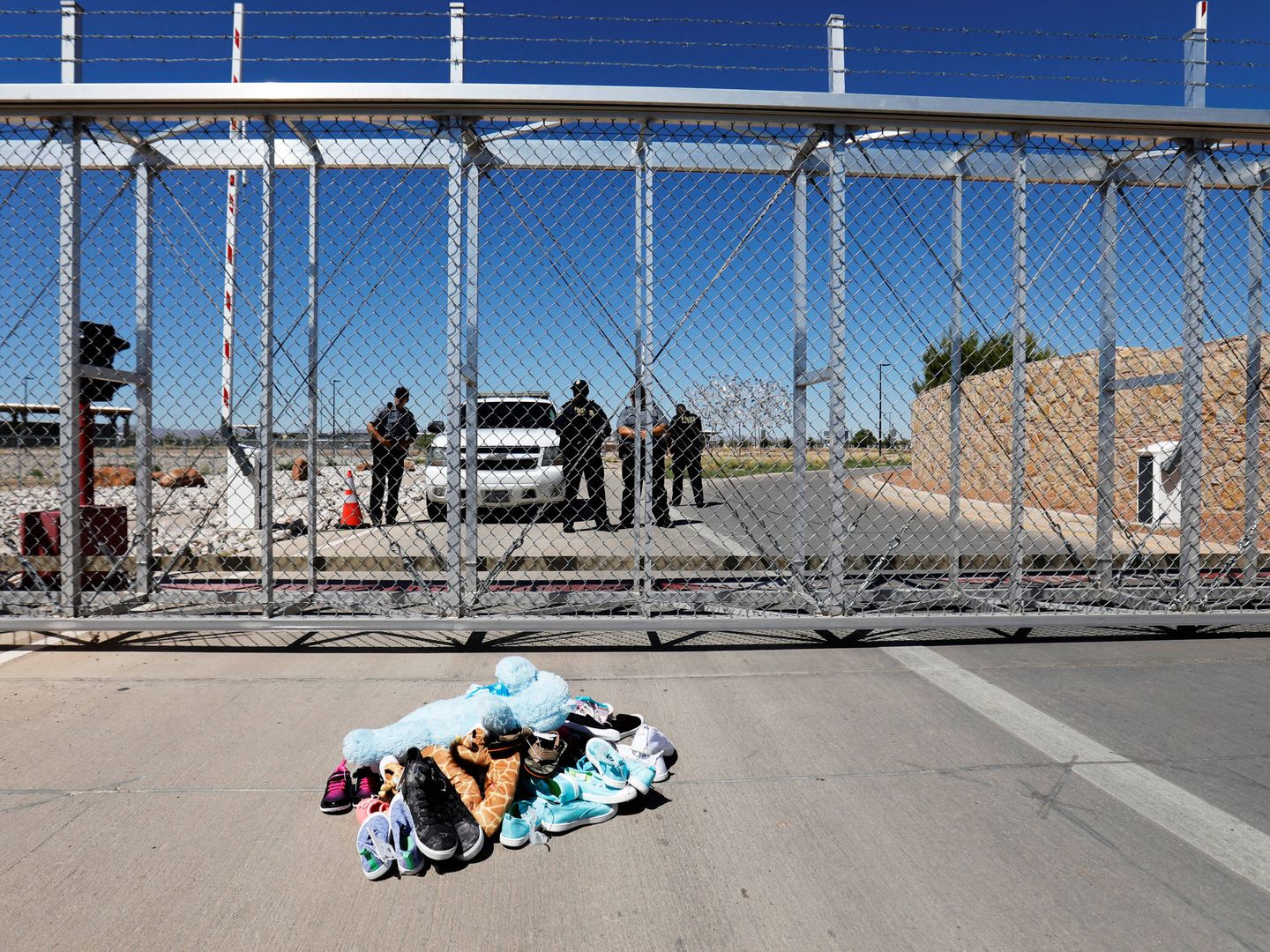 Zapatos y juguetes de niño colocados a modo de protesta frente a la puerta de un centro de detención de menores inmigrantes en Tornillo, Texas, el 21 de junio de 2018. (Reuters)