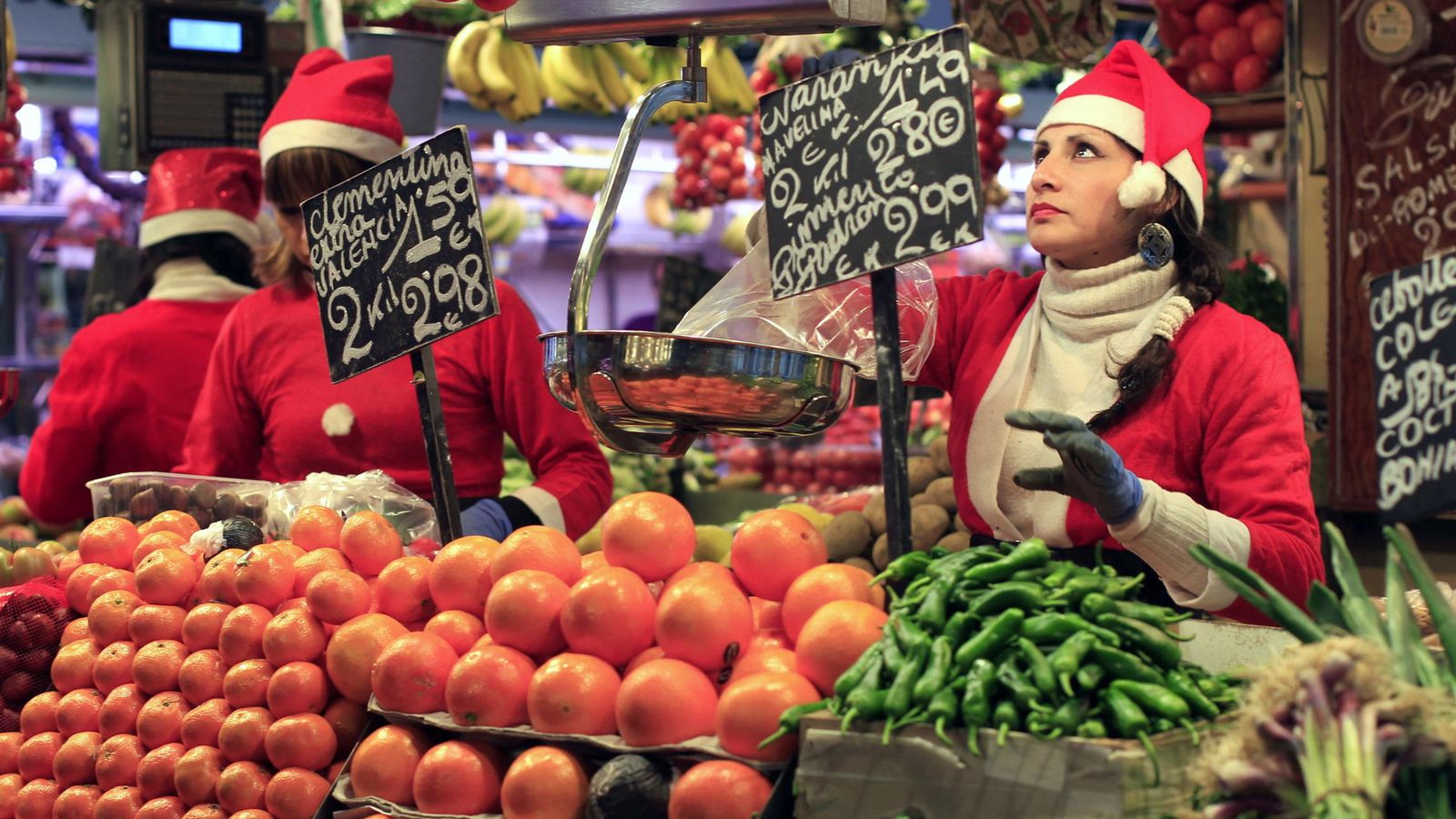 Foto: Compras en una frutería del Mercado de la Boquería de Barcelona para la cena de Nochebuena. (EFE)