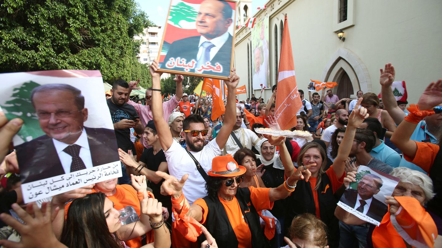 Miembros del Movimiento Patriótico Libre enarbolan imágenes de Michel Aoun tras conocerse su nombramiento (Reuters)