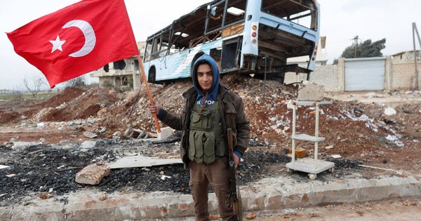 Foto: Un combatiente del Ejército Libre Sirio, apoyado por Turquía, ondea una bandera turca cerca de Azaz, Siria. (Reuters)