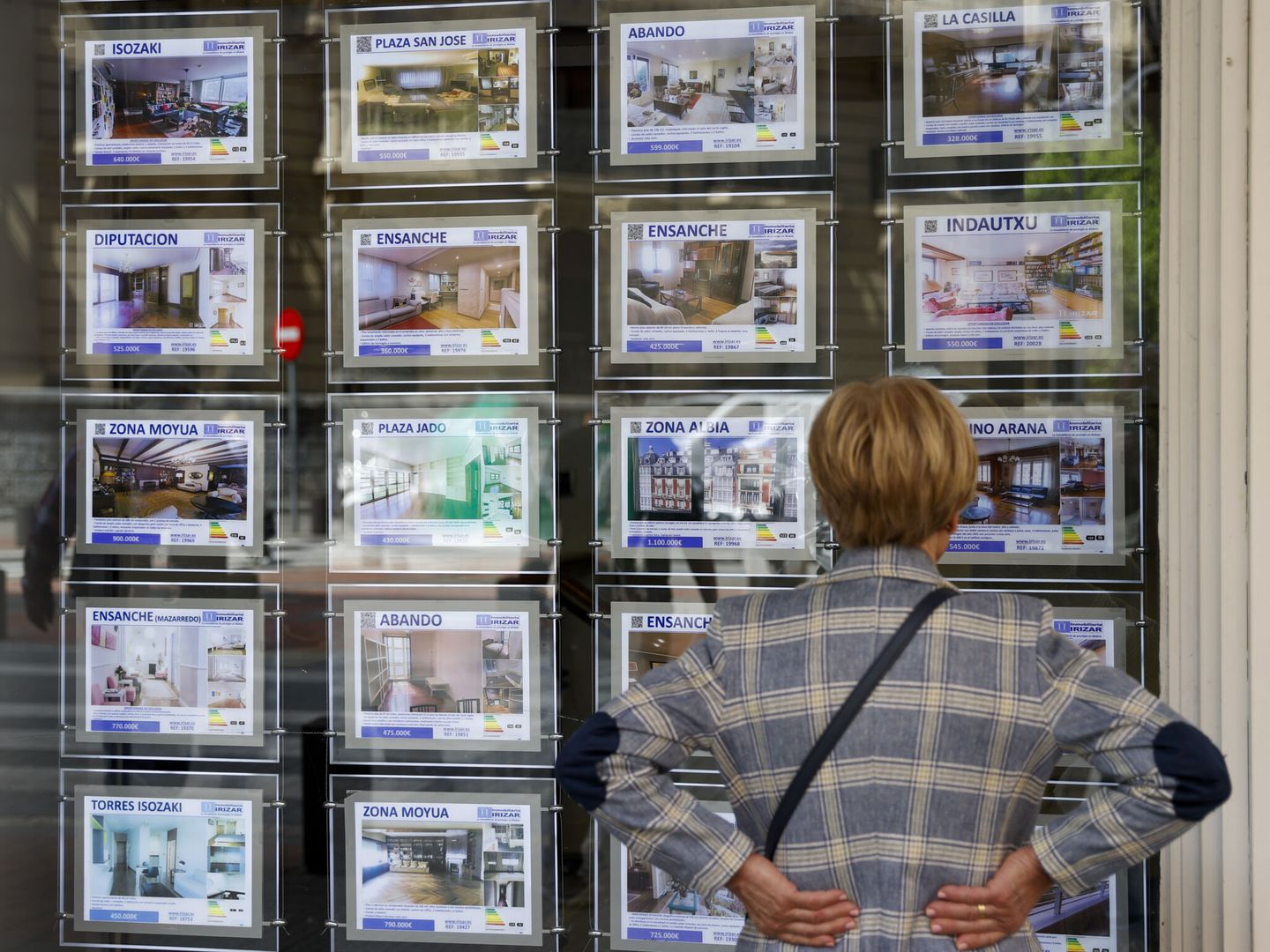 Una mujer mira la oferta de viviendas en una inmobiliaria en Bilbao.