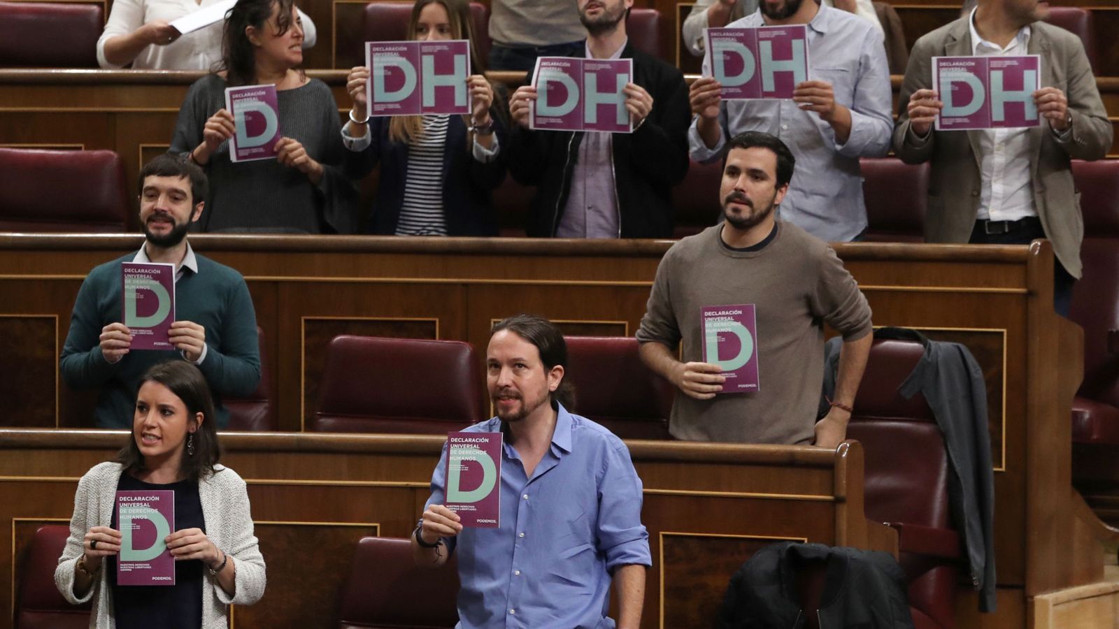 Foto: Diputados de Podemos protestan en el Congreso un día después del motín en un centro de internamiento de extranjeros de Madrid. (EFE)
