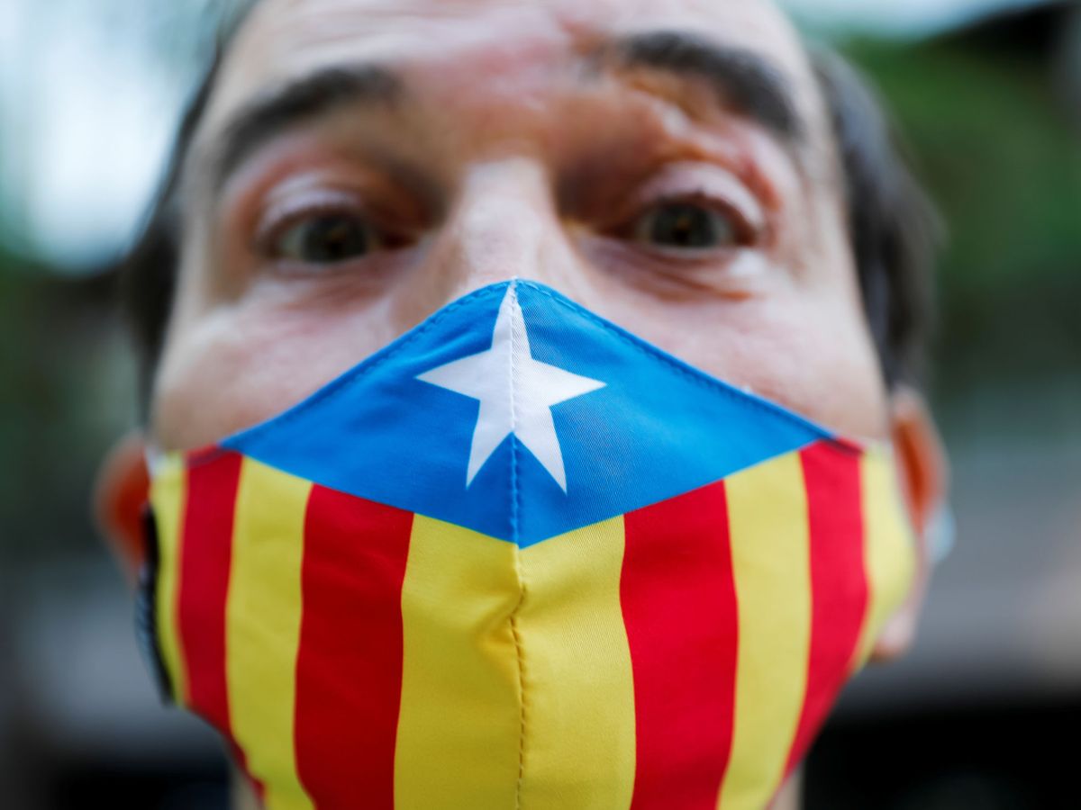 Foto: Una persona independentista llevando una mascarilla con la estelada. (Reuters)