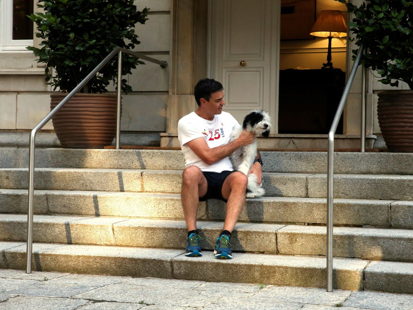 Pedro Sánchez, con una de sus perras en las escaleras de Moncloa. (EFE)