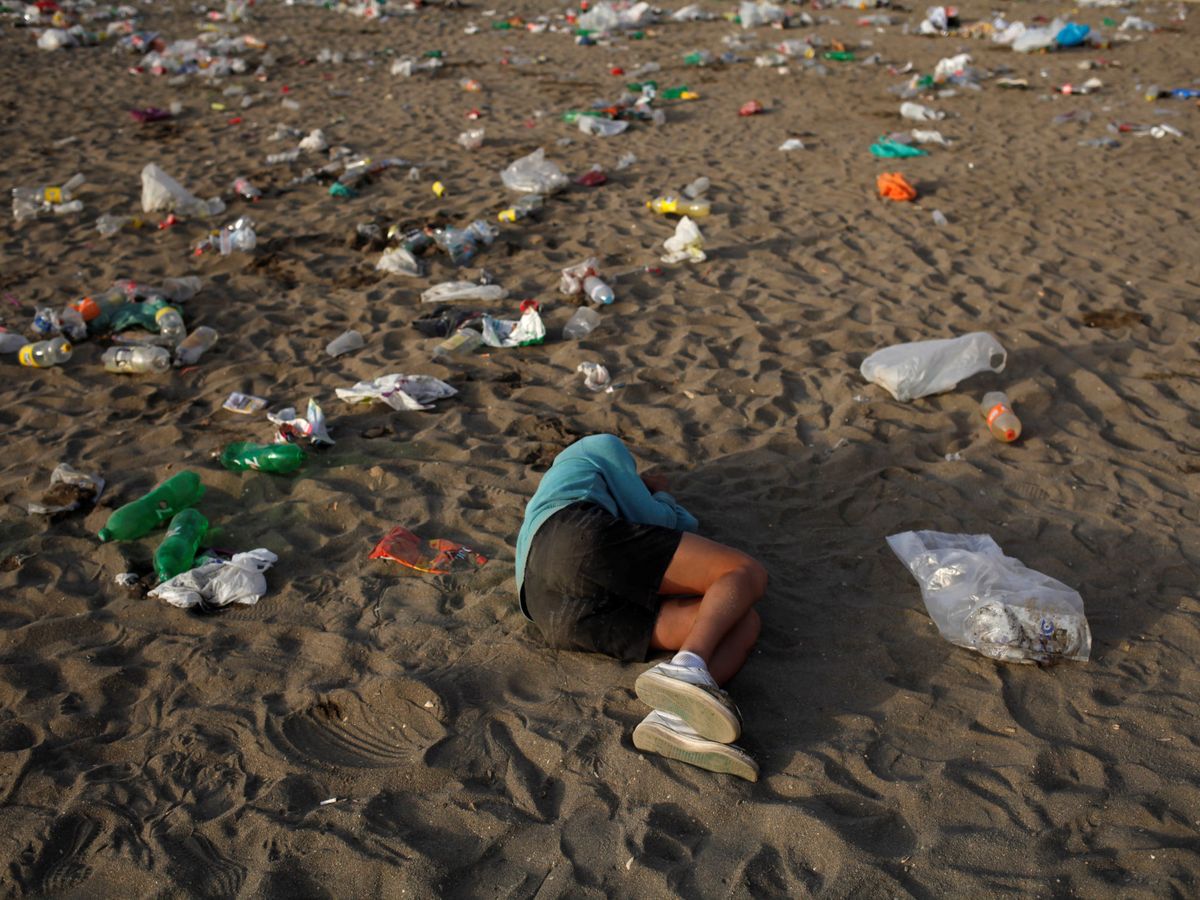 Foto: Un joven duerme rodeado de basura. (Reuters/Jon Nazca)