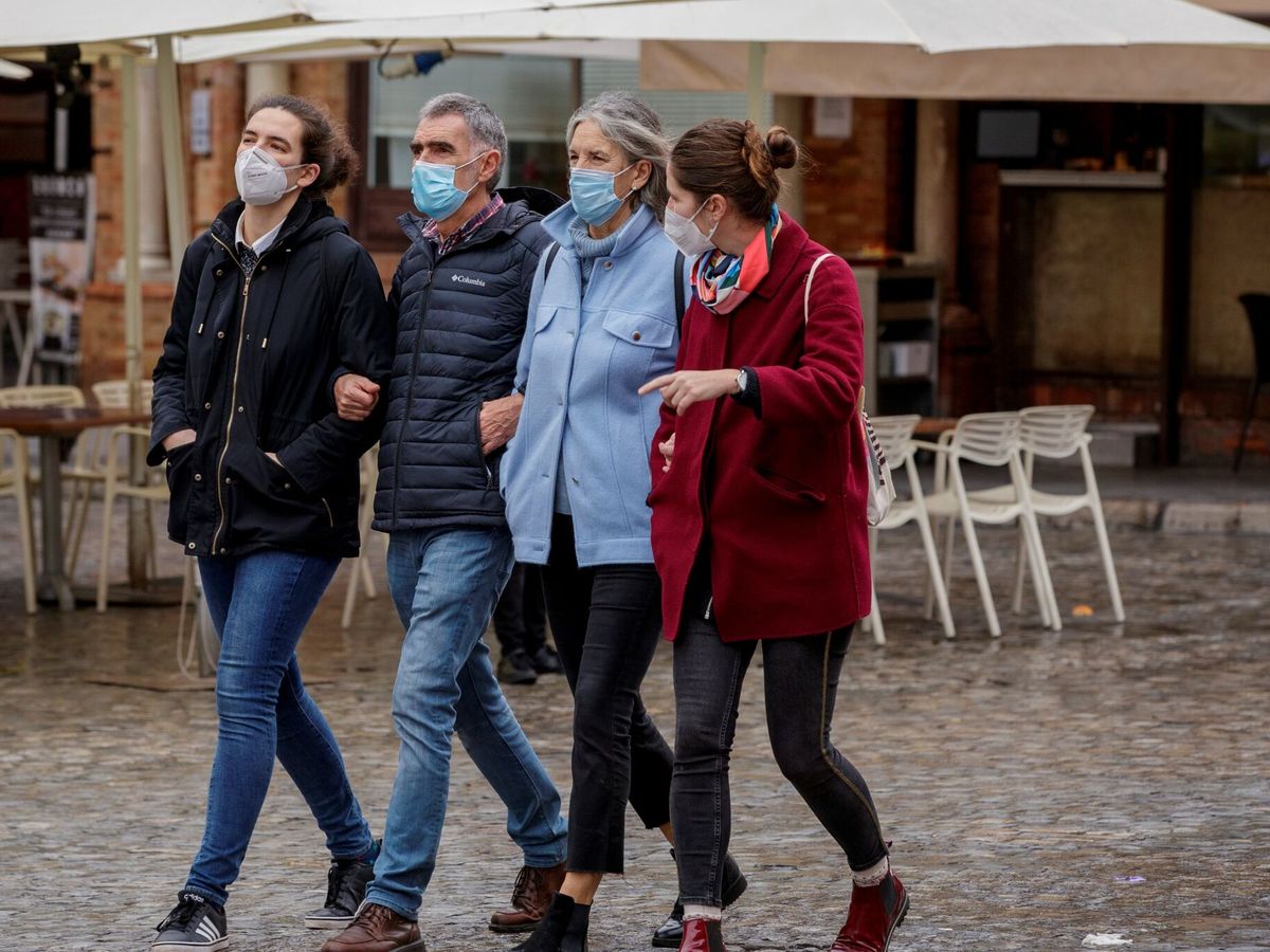 Foto: Varias personas usando mascarillas paseando por la Plaza de San Francisco de Sevilla. (EFE/Julio Muñoz)
