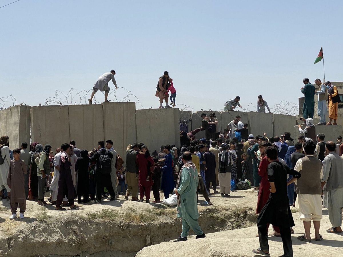 Foto: Decenas de afganos se agolpan a lo largo del muro del aeropuerto de Kabul. (EFE) 