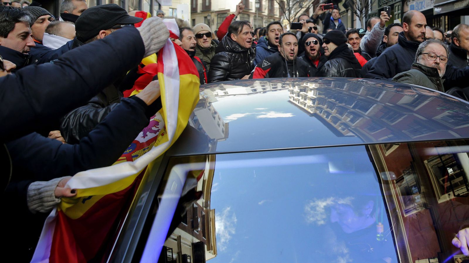 Foto: Policías de Madrid insultan a Javier Barbero y golpean el vehículo en el que viajaba. (EFE)