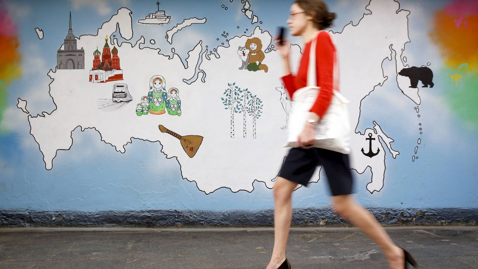Foto: Una mujer pasa por delante de un mural con el mapa de Rusia en Moscú, en junio de 2015. (Reuters)