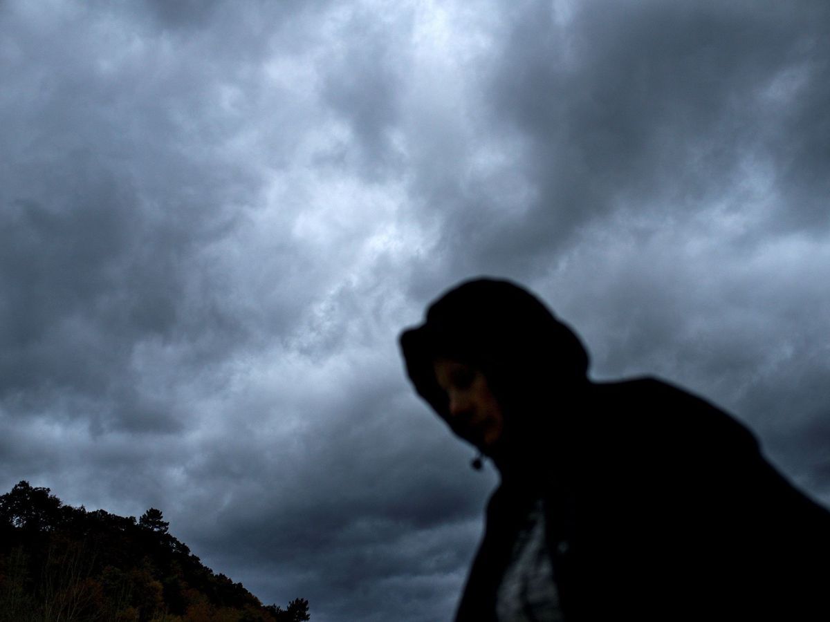 Foto: Una mujer camina bajo el cielo nublado en Ourense. (EFE)