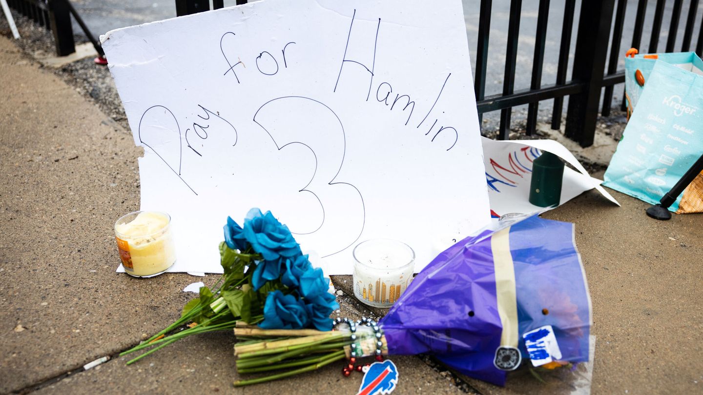 Flores y velas en apoyo a Damar Hamlin en la puerta del hospital University of Cincinnati Medical Center.
