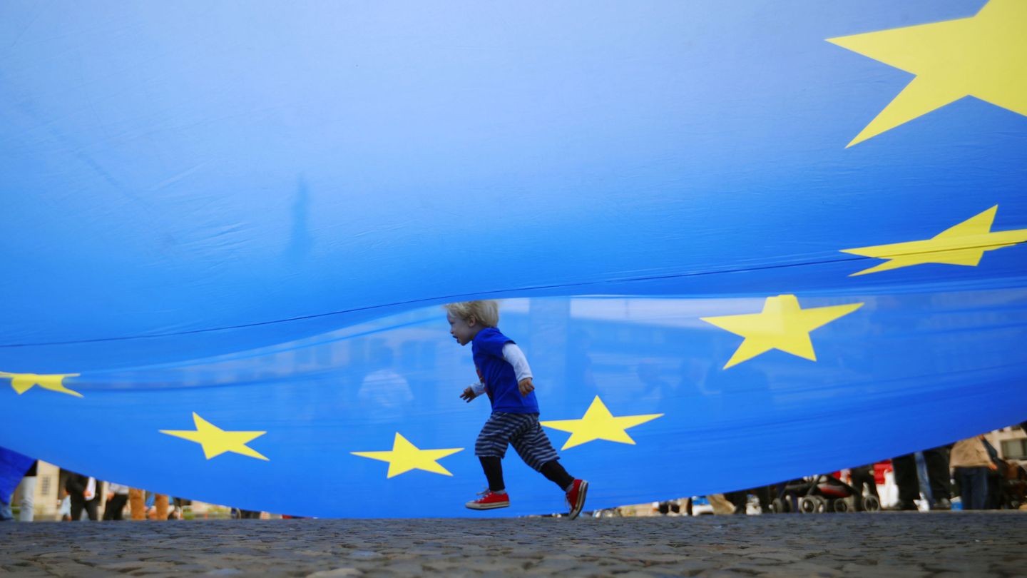 Un niño corre bajo una bandera europea en una manifestación en Berlín (Reuters)