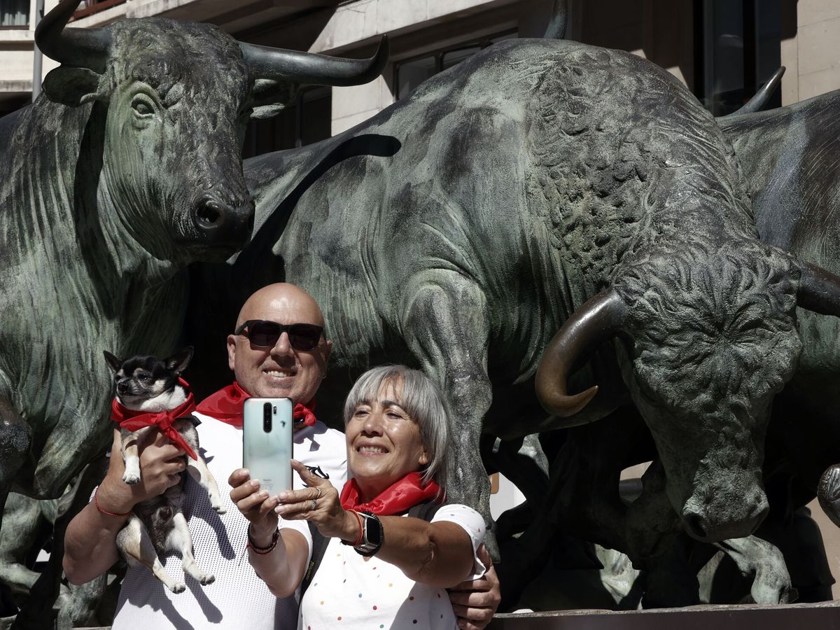 Foto: Dos turistas se hacen un selfi junto al monumento al encierro en Pamplona. (EFE/Jesús Diges)
