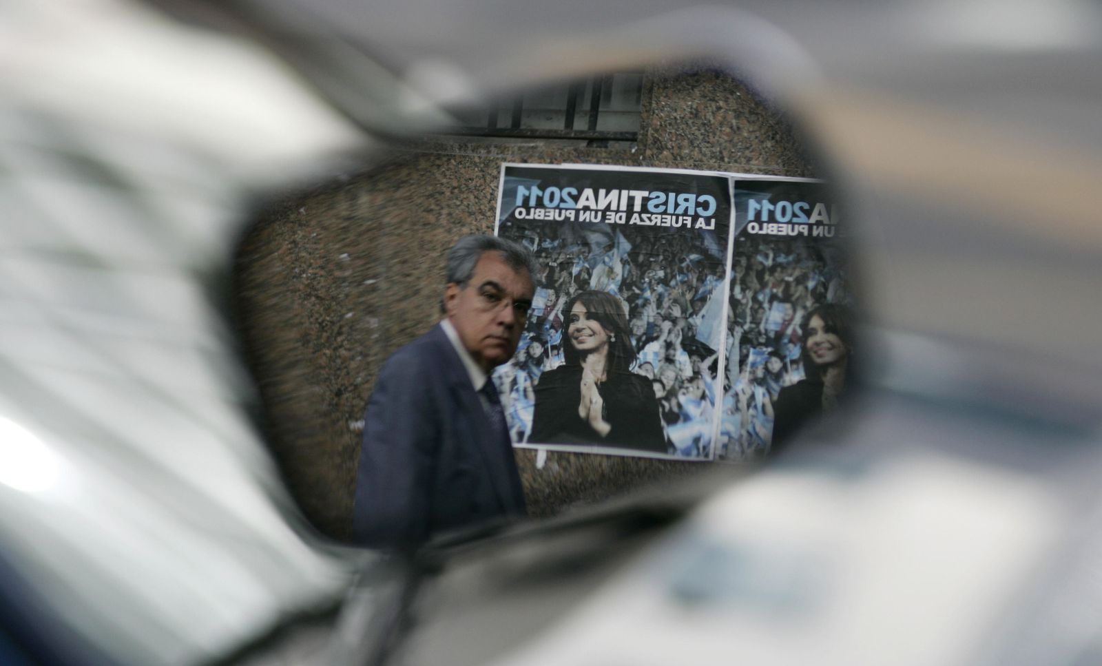 Foto: Un argentino reflejado en el retrovisor de una motocicleta pasa ante un cartel electoral de Cristina Kirchner, en Buenos Aires (Reuters). 