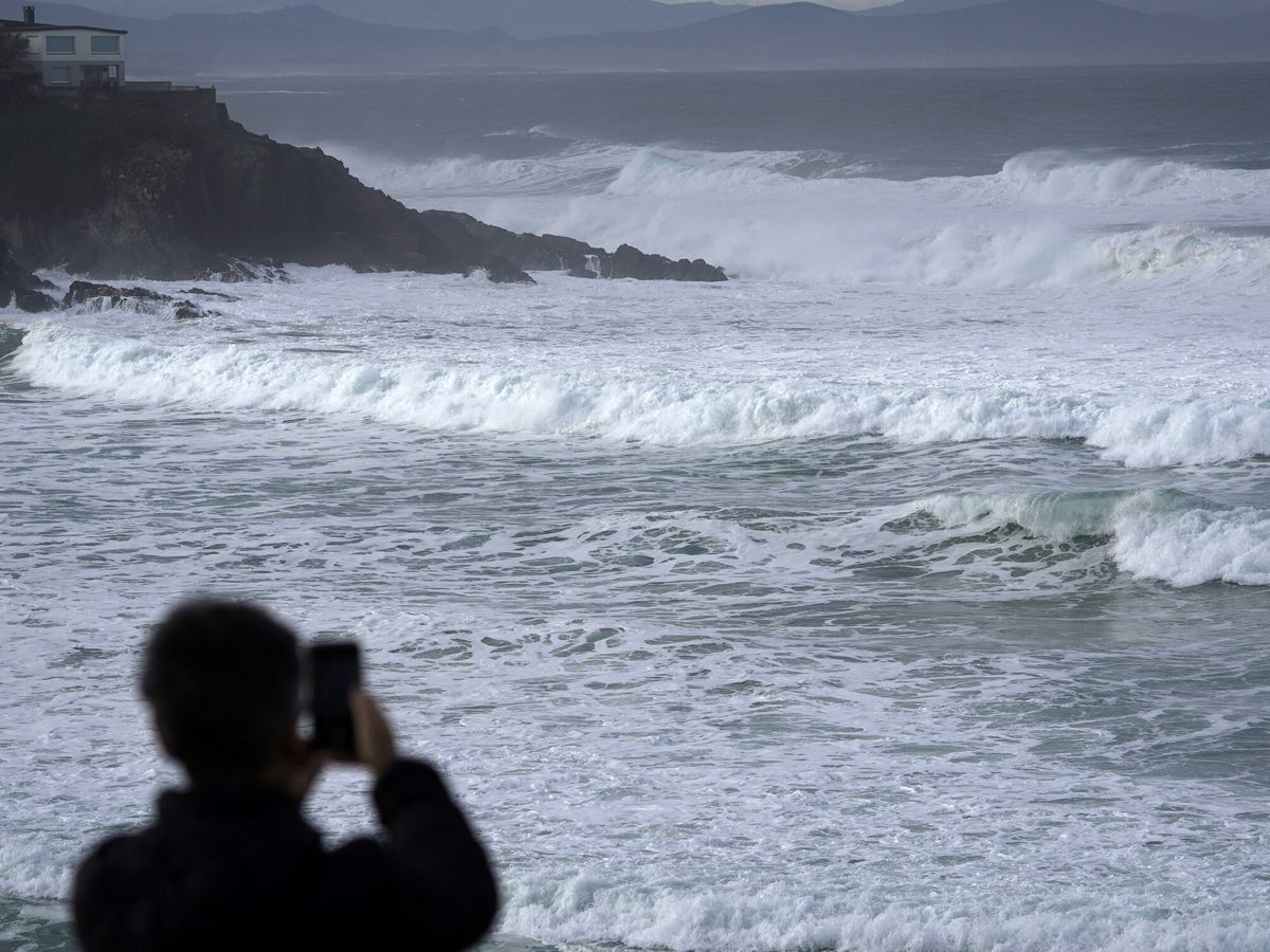 Foto: Una persona haciendo fotos al oleaje en Asturias. (EFE/Paco Paredes)