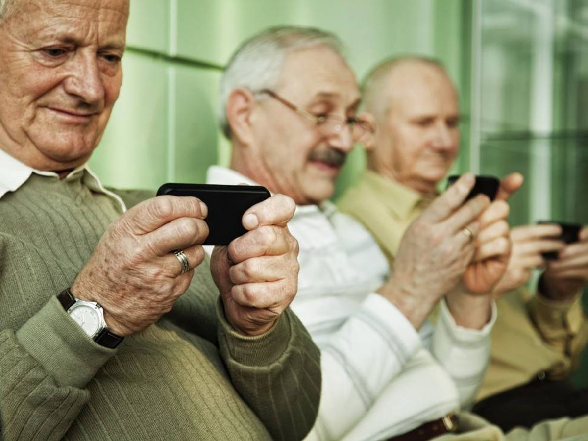 Foto: Tres ancianos usando el teléfono móvil.