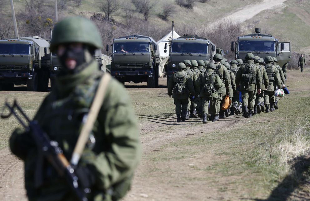 Soldados rusos sin distintivos marchan ante una base ucranianan en Perevalnoye (Reuters).