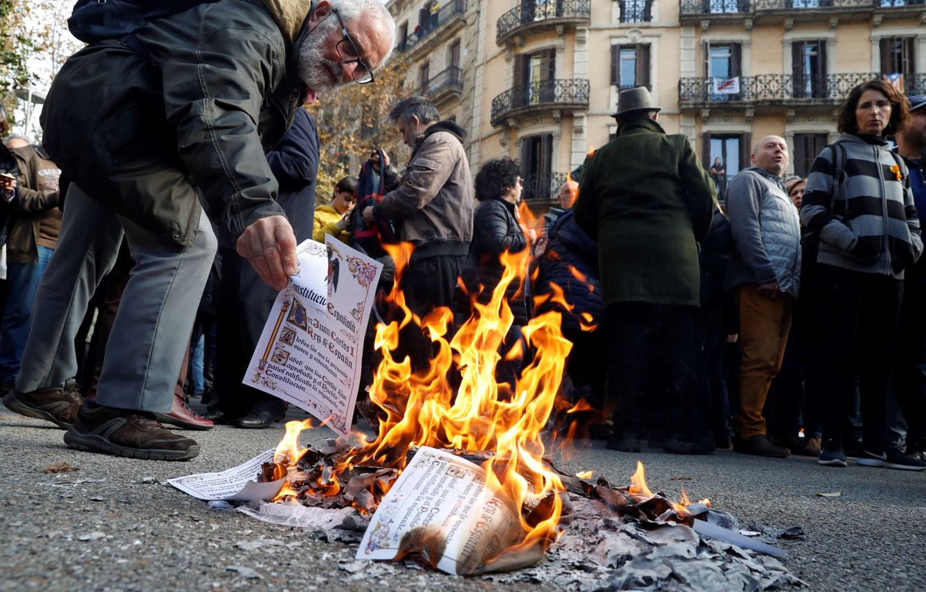 Varias personas queman ejemplares de la Constitución española en las calles de Barcelona. (EFE)