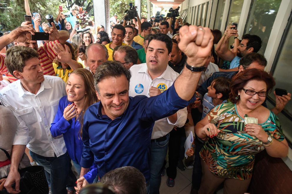 El candidato presidencial Aécio Neves llega para votar un colegio electoral de Belo Horizontes con su mujer (Reuters).