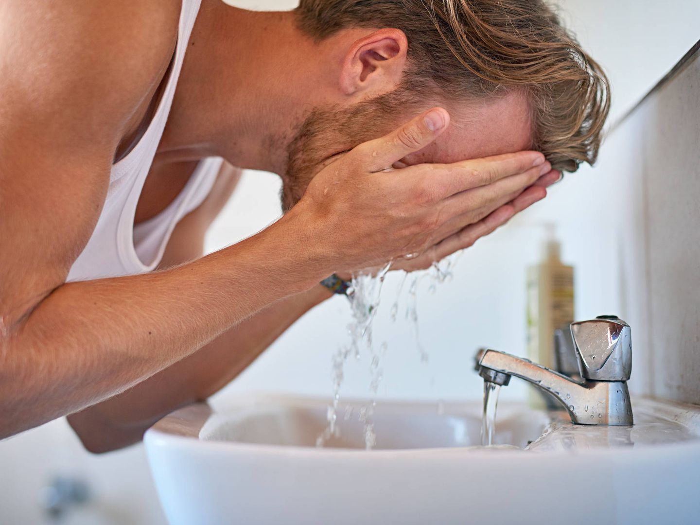 Un hombre se lava la cara en el lavabo. (iStock)