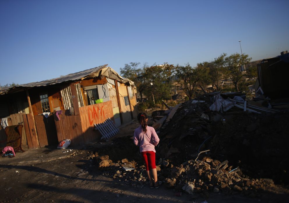 Foto: Un niña mira su casa demolida en El Gallinero (Reuters)