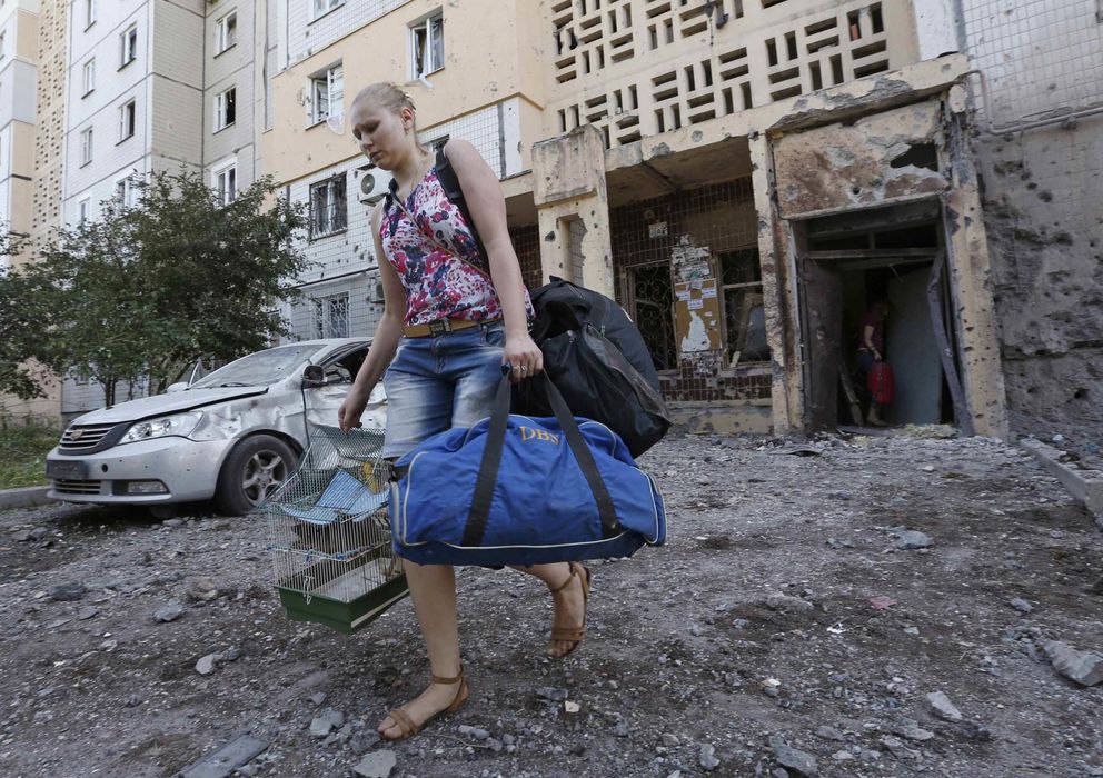 Foto: Una mujer abandona los pisos dañados por los bombardeos en Donétsk. (Reuters)