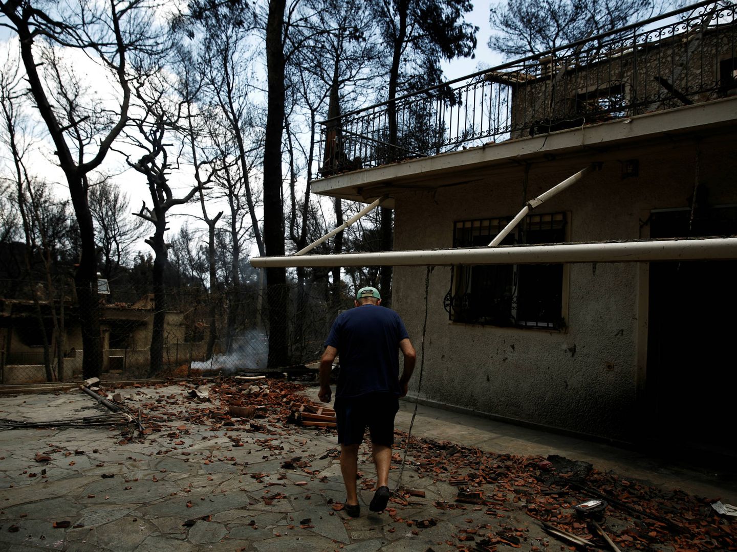 Un hombre ante su casa quemada en el pueblo de Mati, cerca de Atenas. (Reuters)