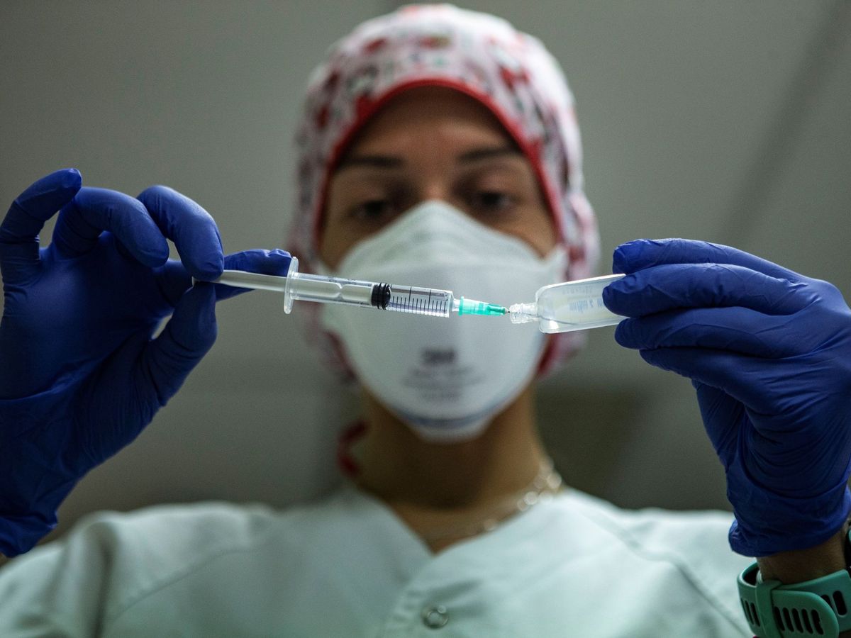 Foto: Una enfermera se dispone a inyectar la primera dosis de la vacuna de Pfizer a una persona. (EFE)
