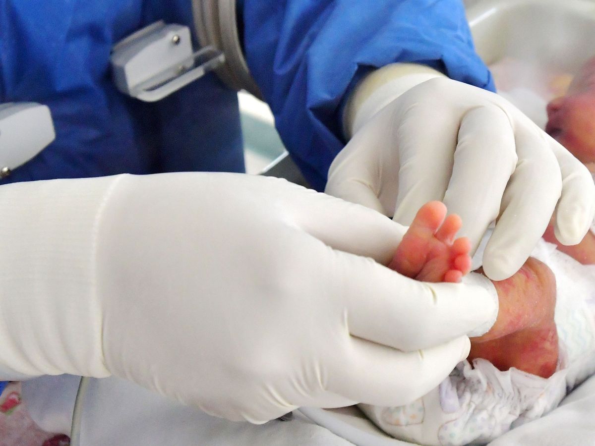 Foto: Personal sanitario atiende a un recién nacido con sospecha de covid-19. (EFE)